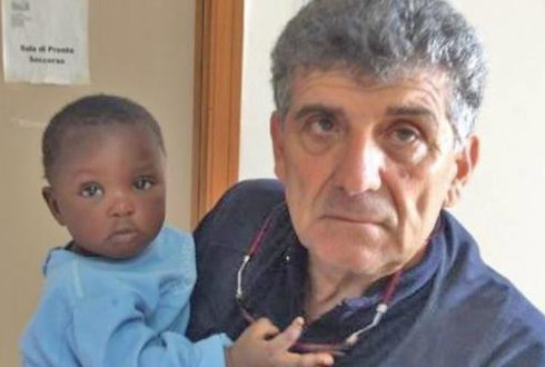 Il dottor Pietro Bartolo tiene in braccio un piccolo bambino