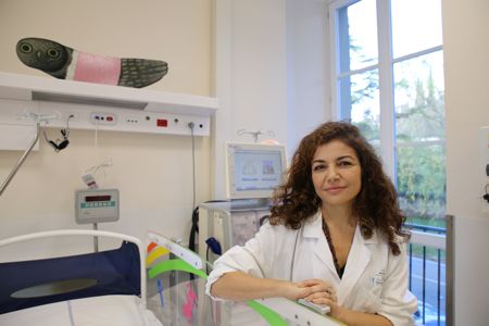 Foto della professoressa Paola Romagnani seduta vicino ad un letto nel reparto di Nefrologia e Dialisi dell'ospedale Meyer