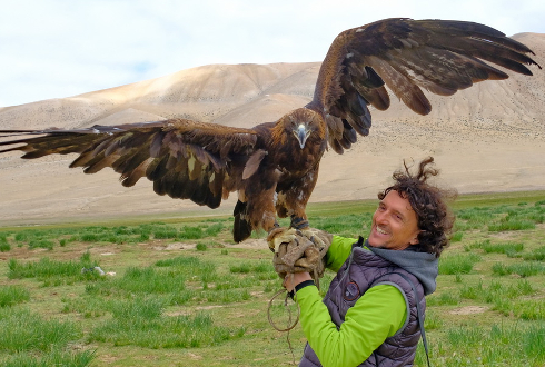 Foto del fotografo Luca Bracali con un'aquila appoggiata sul suo braccio