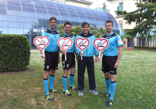 Quattro arbitri di calcio alzano la paletta del divieto di fumo nel parco del Meyer