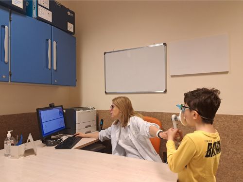 Foto Dott.ssa Fenu del Meyer che effettua spirometria a un bambino