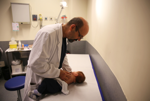 Foto di Cesare Filippeschi, dermatologo del Meyer, mentre visita un piccolo paziente